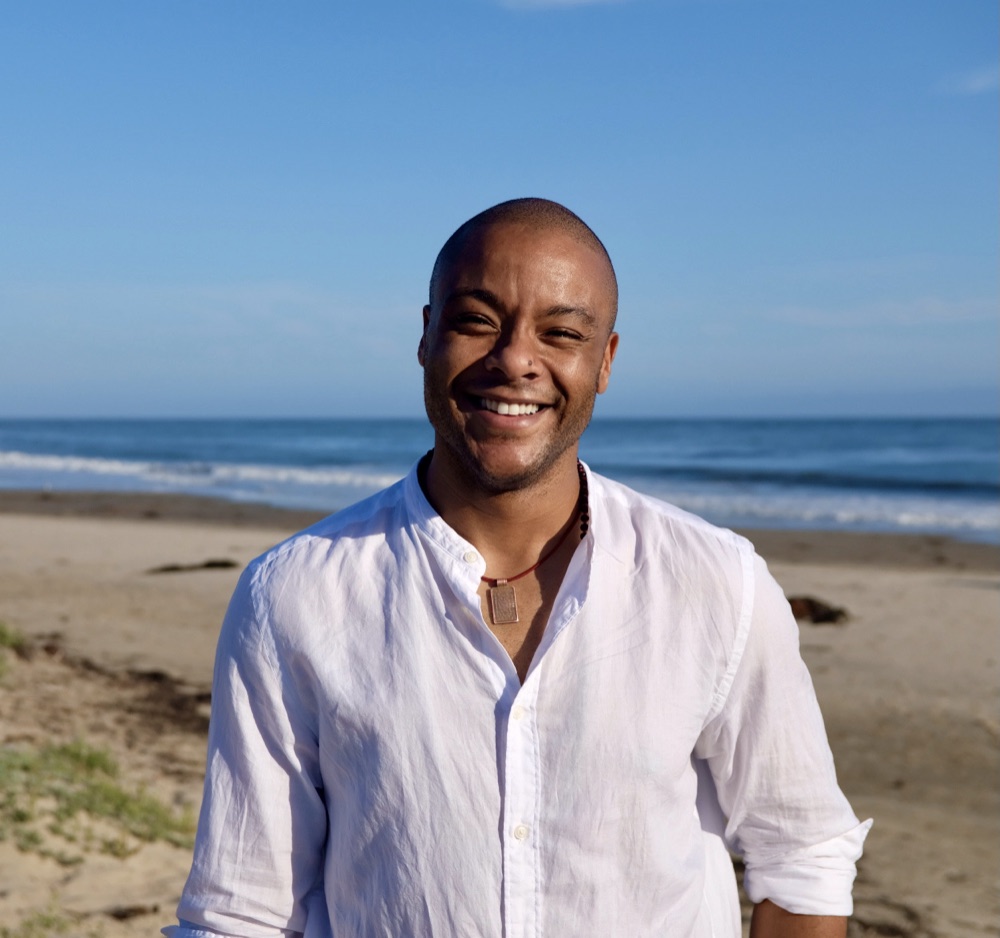 Jaymes W. Johnson, seated outdoors on the California coast.